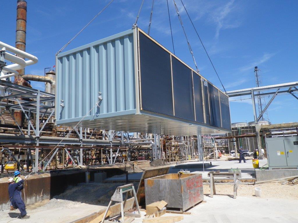 Modular building being lowered at construction site.