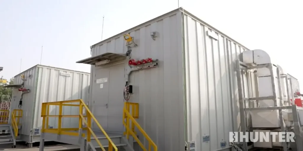 Rear view of a white custom modular control room with yellow railings
