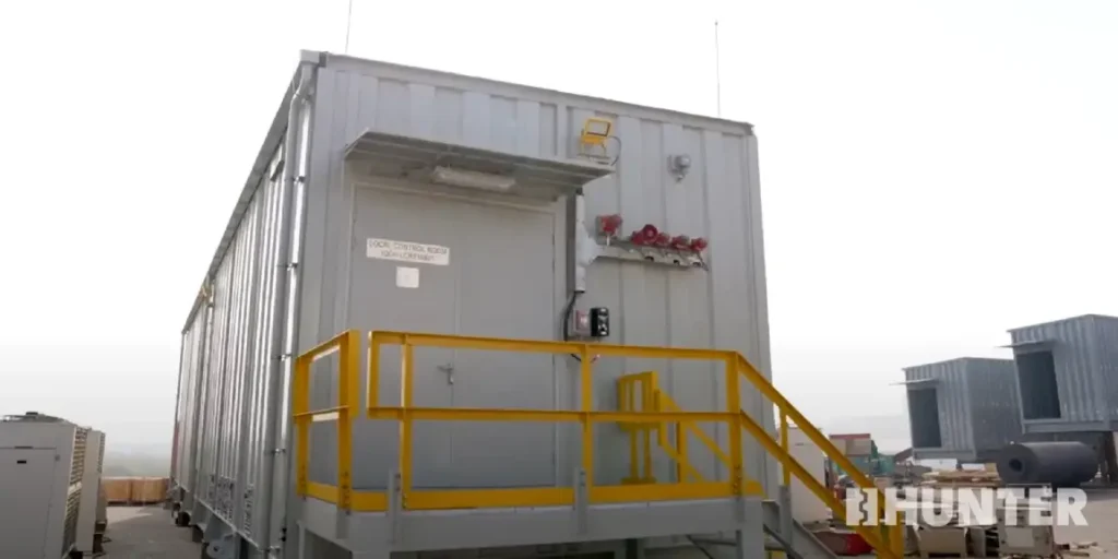 White custom modular control room modules with yellow railings